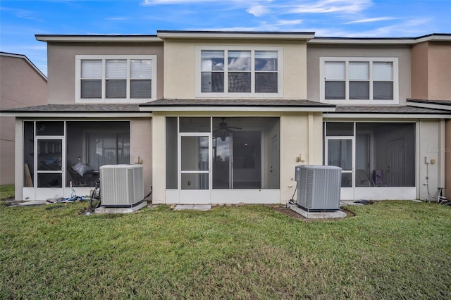 back of property featuring a sunroom, a yard, and central AC unit