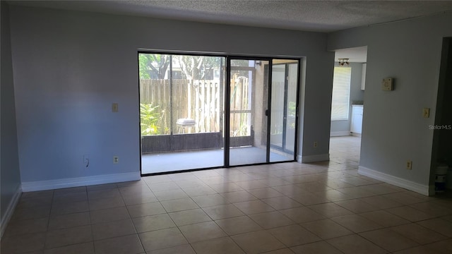 empty room with tile patterned floors and a textured ceiling