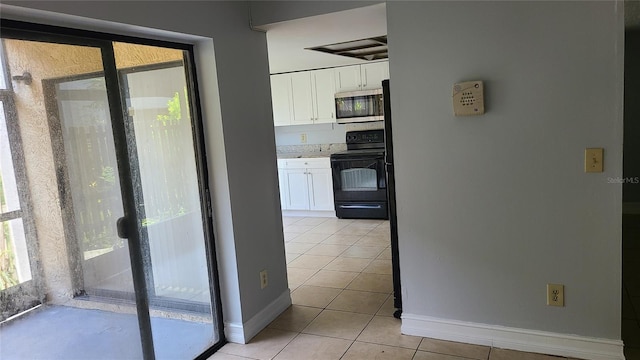 kitchen featuring white cabinetry, black range with electric stovetop, and light tile patterned floors