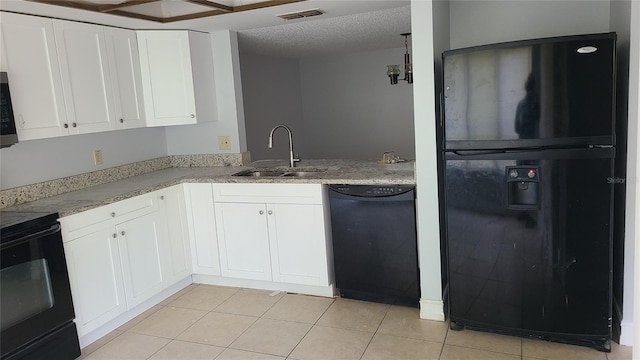 kitchen with sink, white cabinets, light tile patterned floors, black appliances, and a textured ceiling