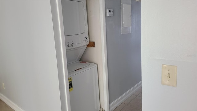 clothes washing area featuring stacked washer / drying machine and light tile patterned floors