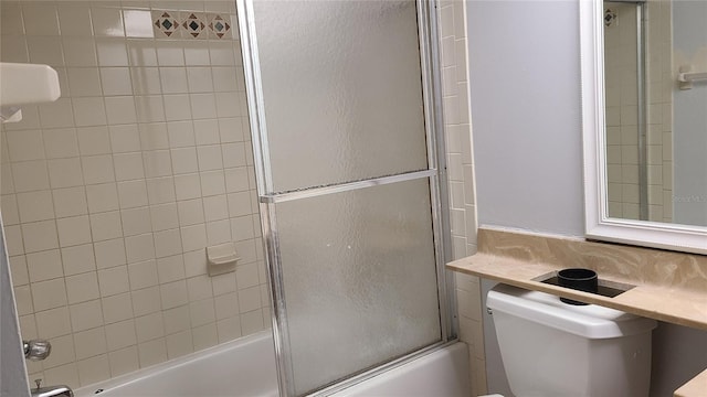 bathroom with bath / shower combo with glass door and toilet