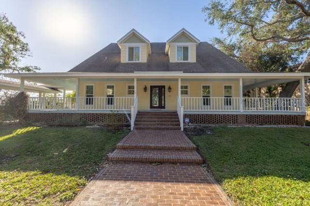 farmhouse-style home featuring a porch and a front lawn