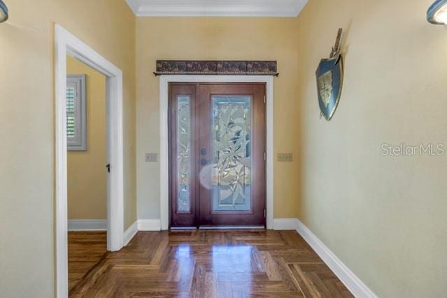 entrance foyer featuring dark parquet flooring, a wealth of natural light, and crown molding