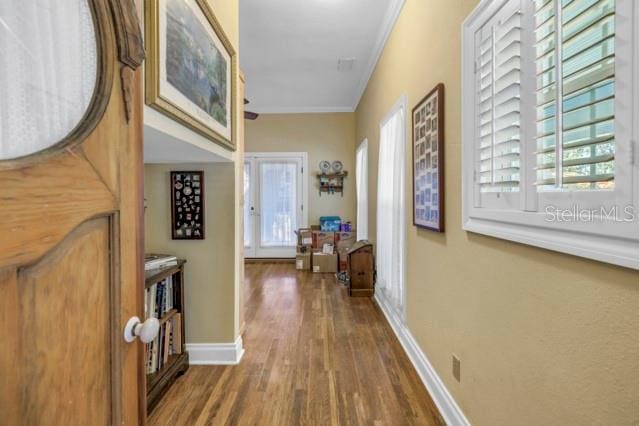 corridor featuring ornamental molding and dark wood-type flooring