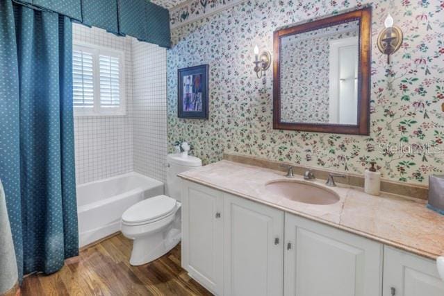 full bathroom featuring vanity, toilet, wood-type flooring, and shower / tub combo