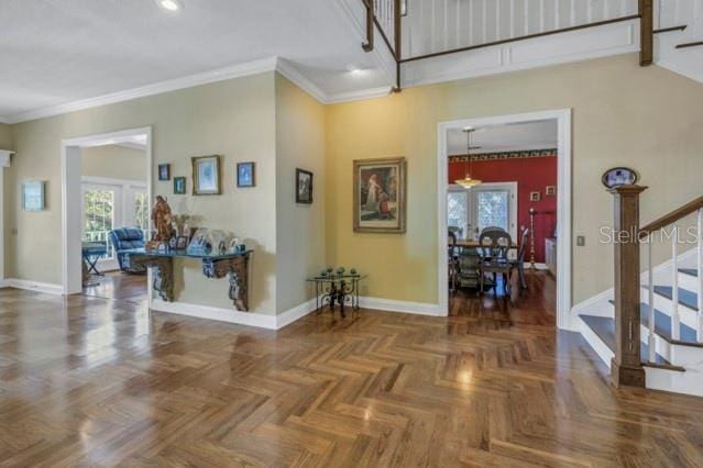 foyer entrance featuring dark parquet flooring, french doors, and ornamental molding