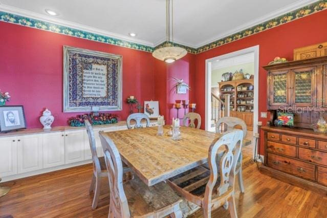 dining area with ornamental molding and hardwood / wood-style flooring