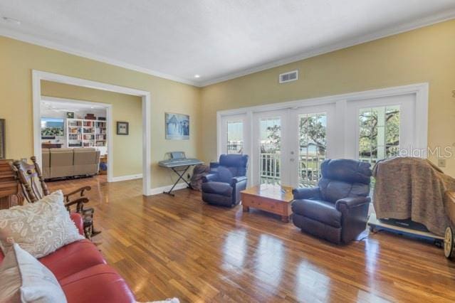 living room featuring crown molding, french doors, and wood-type flooring