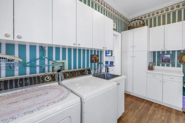 washroom with cabinets, sink, crown molding, dark hardwood / wood-style floors, and separate washer and dryer