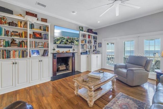 living room with ceiling fan, crown molding, and dark hardwood / wood-style floors