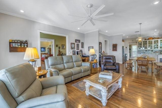 living room with ceiling fan, wood-type flooring, and ornamental molding