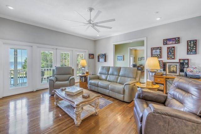 living room featuring french doors, light hardwood / wood-style floors, ceiling fan, and ornamental molding