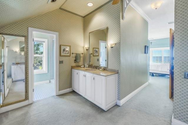 bathroom with ceiling fan, vanity, vaulted ceiling, and ornamental molding