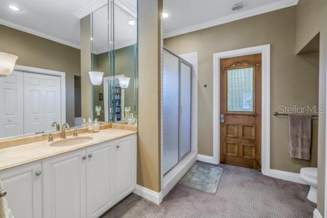 bathroom featuring ornamental molding, vanity, toilet, and a shower with shower door