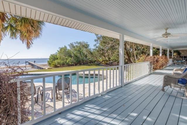 wooden terrace featuring a water view and ceiling fan