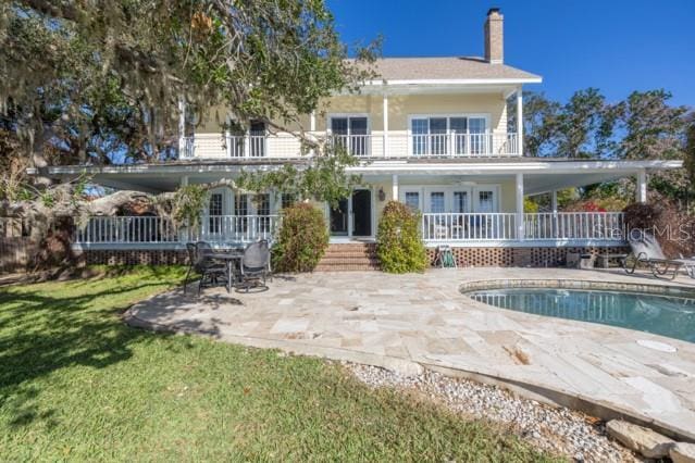 rear view of house featuring a patio and a balcony