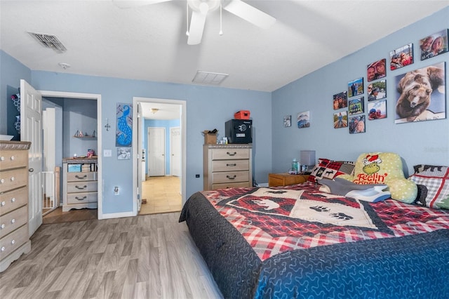 bedroom featuring visible vents, baseboards, wood finished floors, and a ceiling fan