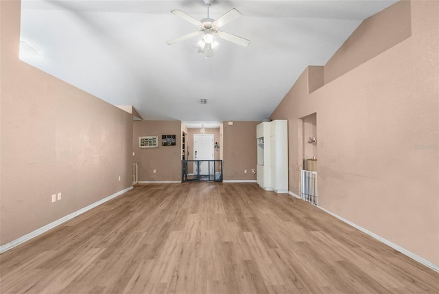 unfurnished living room featuring ceiling fan, baseboards, lofted ceiling, and wood finished floors