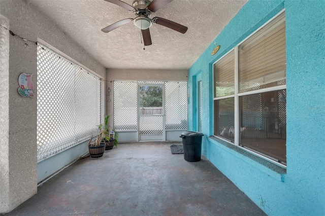 unfurnished sunroom with a ceiling fan