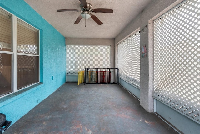 unfurnished sunroom featuring ceiling fan