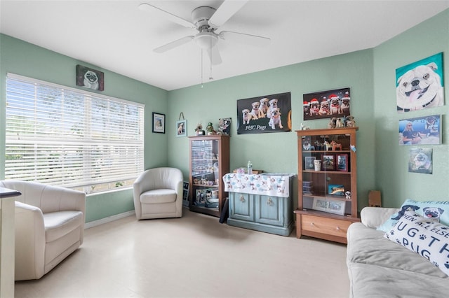 sitting room featuring a ceiling fan and baseboards