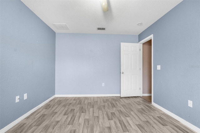 empty room with visible vents, baseboards, and light wood-style flooring