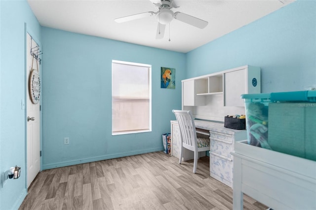 office featuring baseboards, a ceiling fan, and light wood finished floors