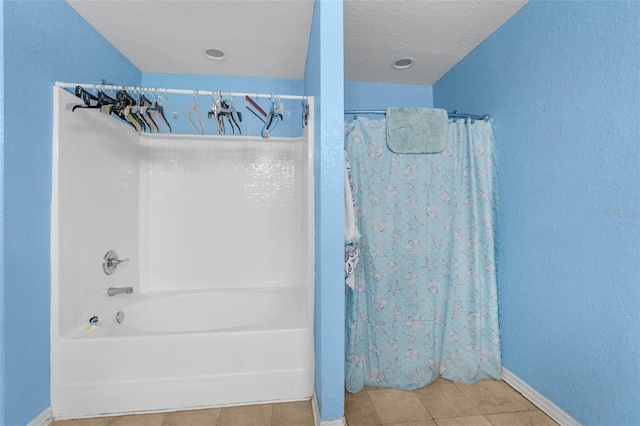 full bath with tile patterned flooring, a textured ceiling, and baseboards