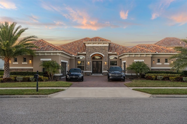 mediterranean / spanish house with a yard and french doors