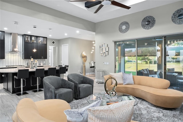 living room featuring ceiling fan and light hardwood / wood-style floors