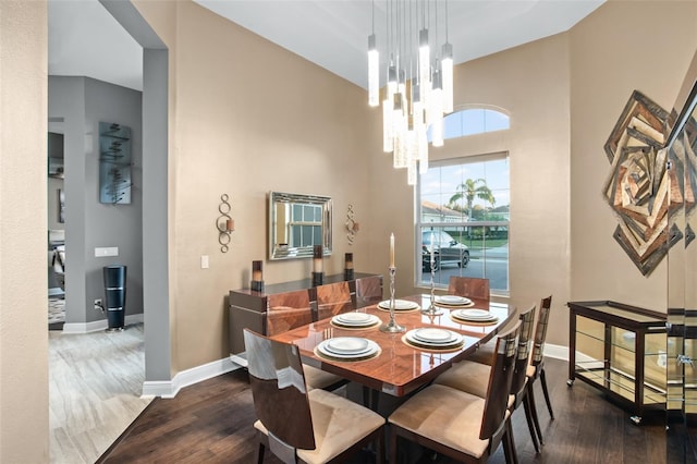 dining area with dark hardwood / wood-style flooring and an inviting chandelier