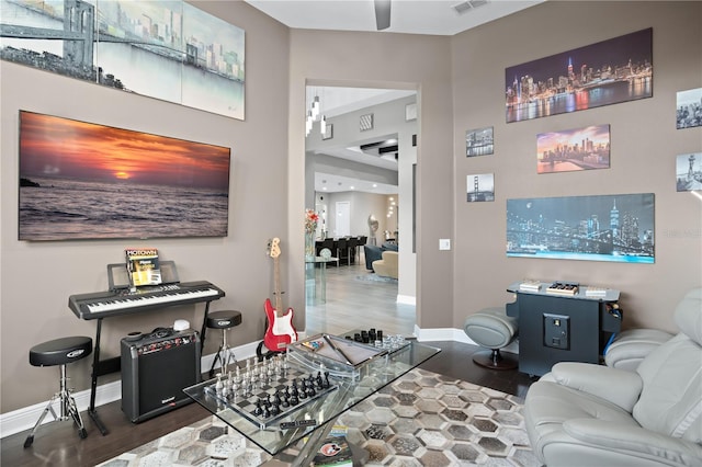 living room featuring dark wood-type flooring and ceiling fan