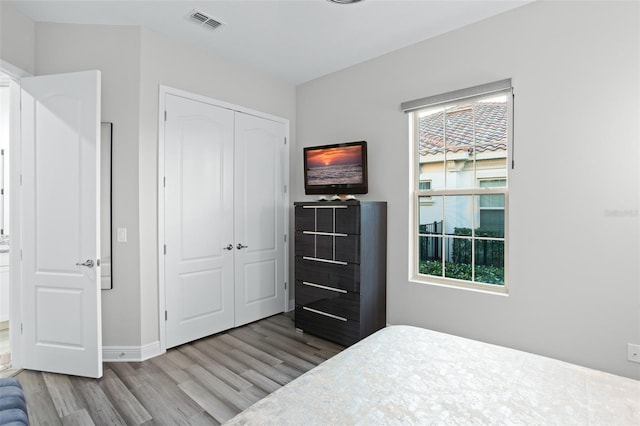 bedroom with a closet and light hardwood / wood-style flooring