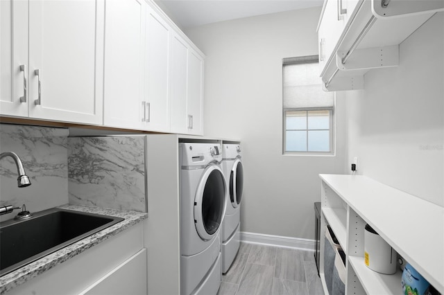 laundry area featuring sink, cabinets, and independent washer and dryer