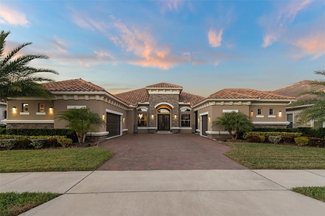 mediterranean / spanish home with a garage and a yard