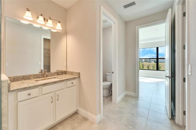 bathroom with toilet, tile patterned floors, and vanity