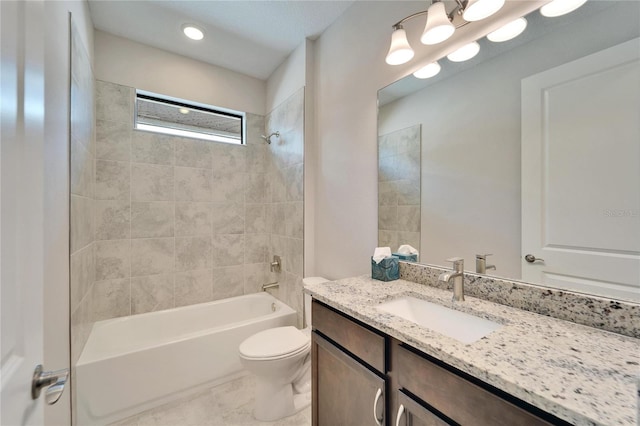 full bathroom with vanity, tiled shower / bath combo, and toilet