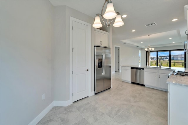 kitchen featuring a chandelier, stainless steel appliances, white cabinets, decorative light fixtures, and sink