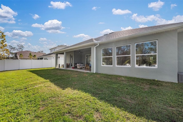 back of house with a patio area and a lawn