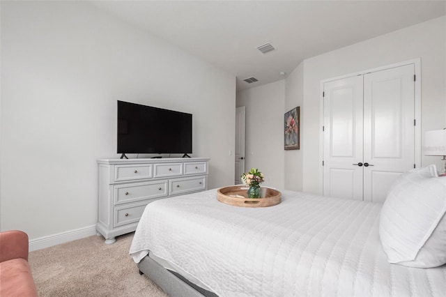 bedroom with light carpet and a closet