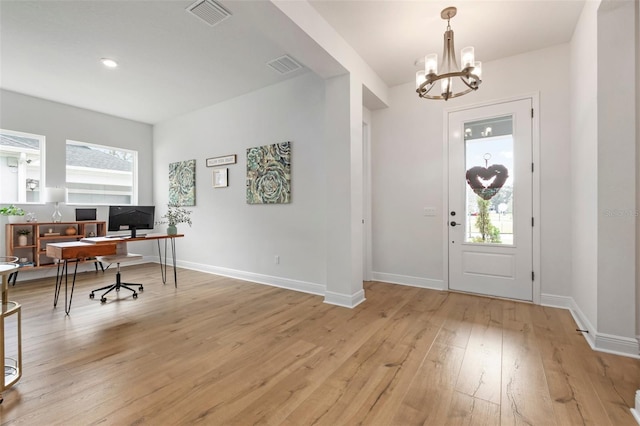 entryway featuring light hardwood / wood-style flooring, a healthy amount of sunlight, and a notable chandelier