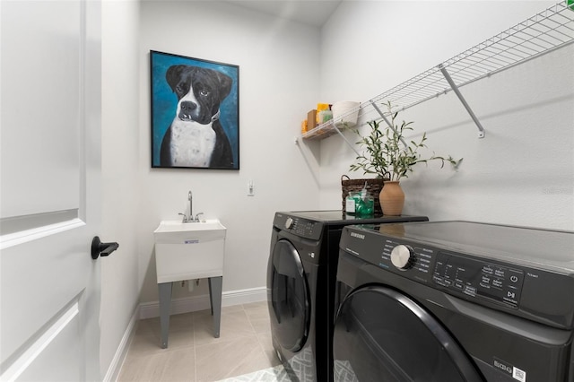 washroom with light tile patterned floors and washer and dryer