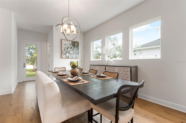 dining space featuring light hardwood / wood-style floors, a wealth of natural light, and a chandelier