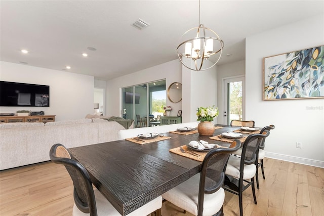 dining space featuring an inviting chandelier and light wood-type flooring