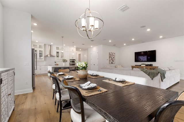 dining area with a chandelier and light wood-type flooring