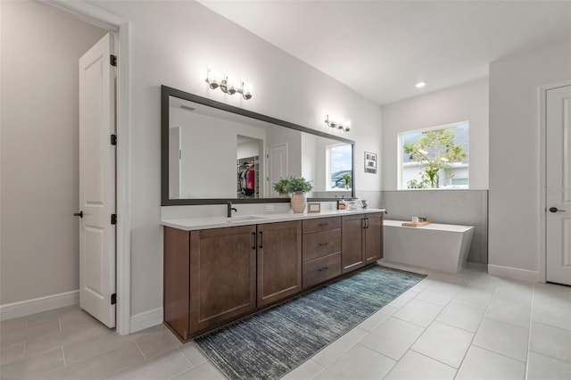 bathroom with tile patterned floors, vanity, and a bath