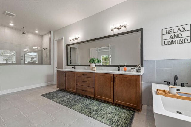 bathroom featuring tile patterned floors, separate shower and tub, vanity, and tile walls