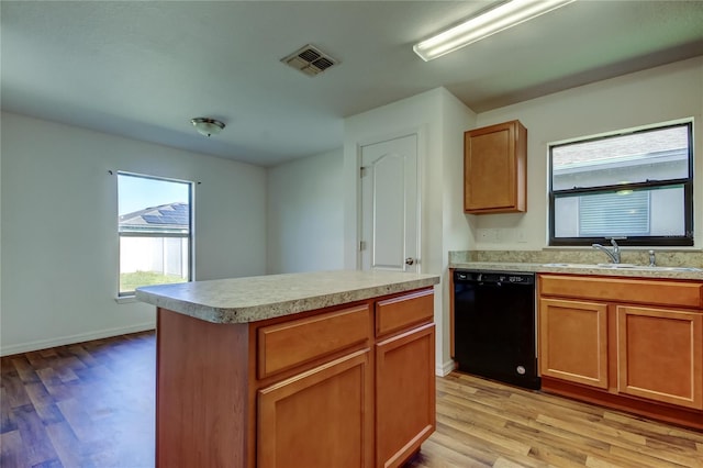 kitchen with light wood-type flooring, dishwasher, a center island, and sink