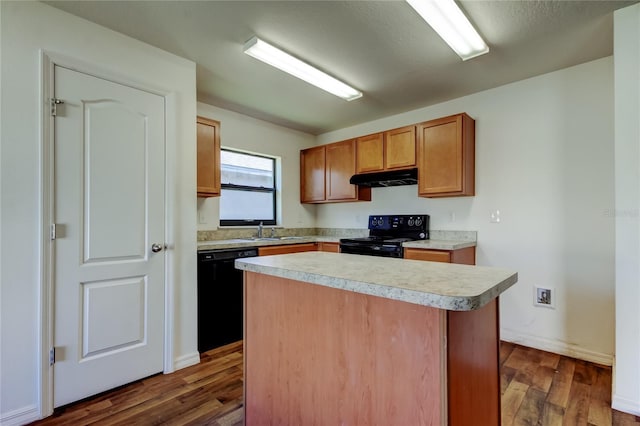 kitchen with dark wood-type flooring, sink, black appliances, and a center island